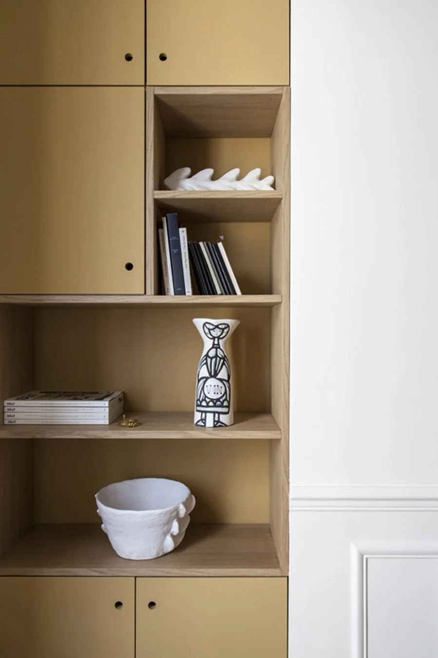 Etagère en bois avec des livres, des objets décoratifs, et un panier blanc