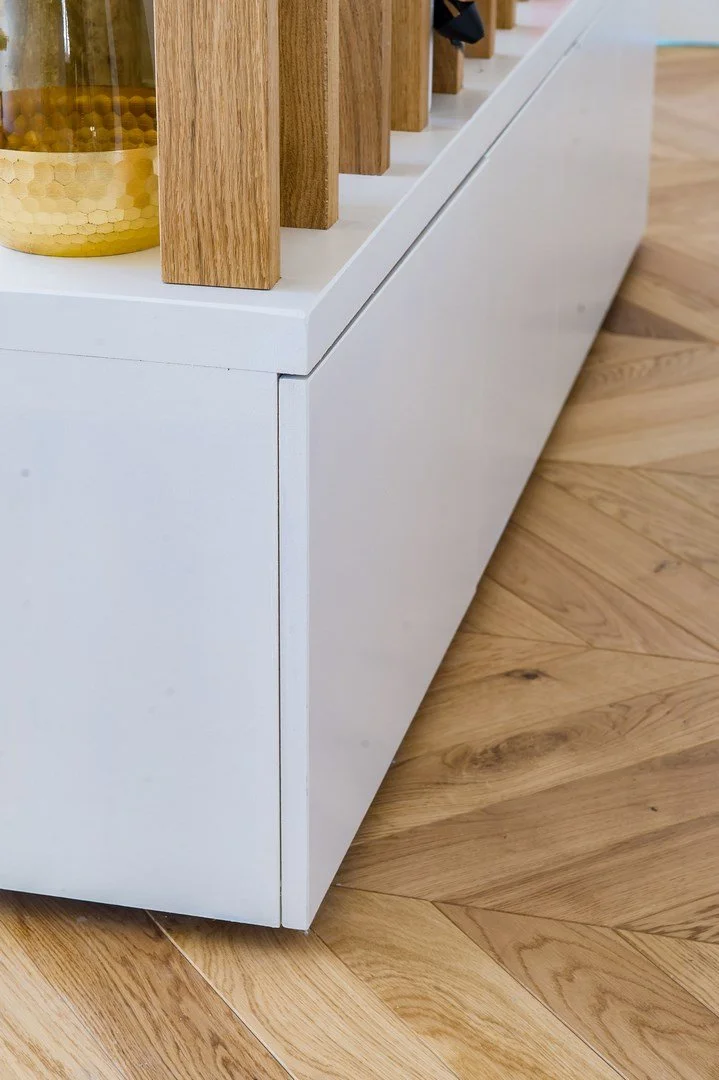 Meuble blanc avec une surface en bois, placé sur un sol en bois clair.