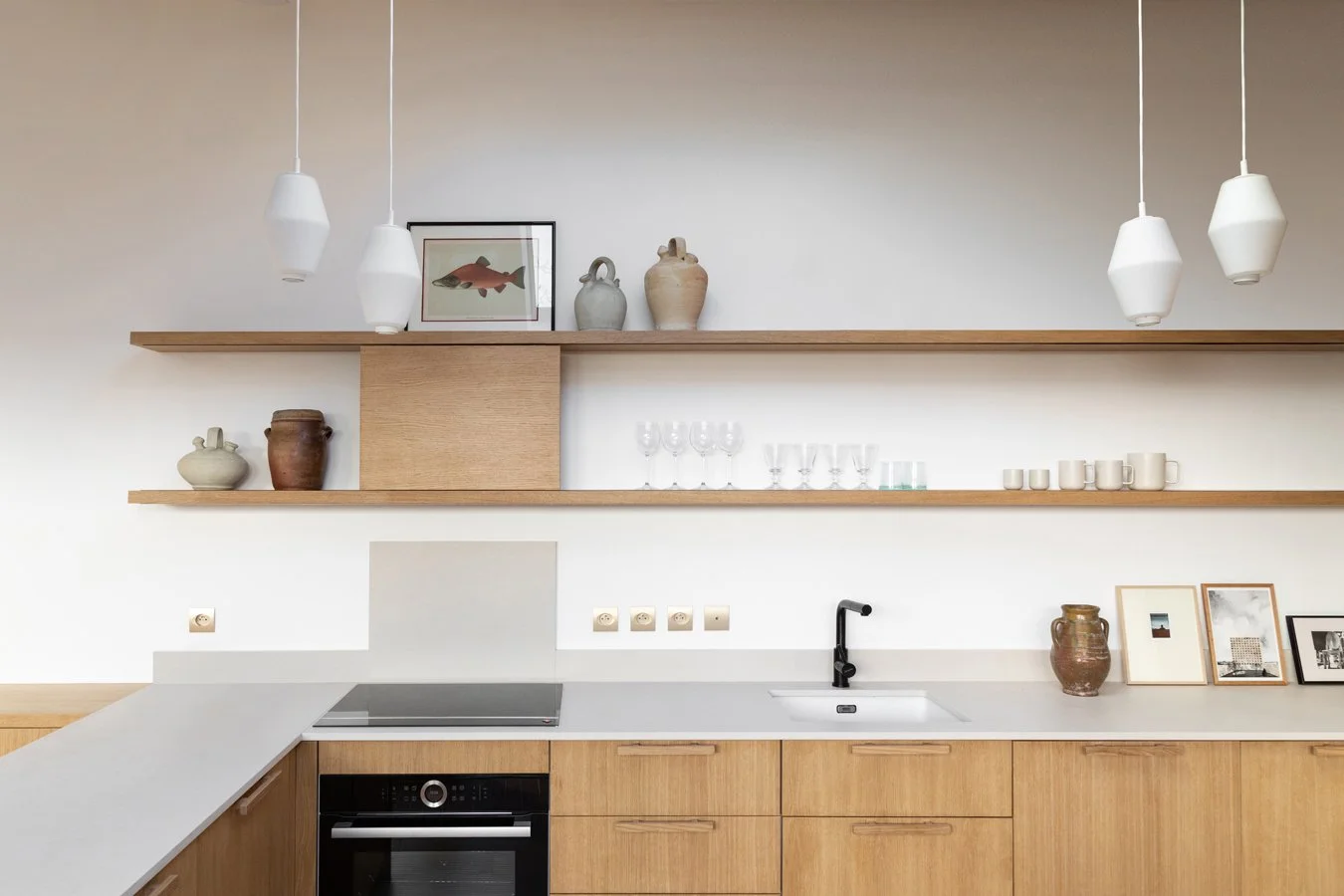 Cuisine moderne avec étagères en bois, vaisselle, vases, cadre photo, et lampes suspendues
