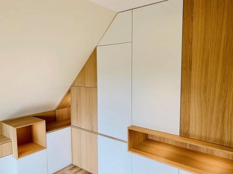 Cloison en bois et blanc avec étagères intégrées dans une pièce moderne.