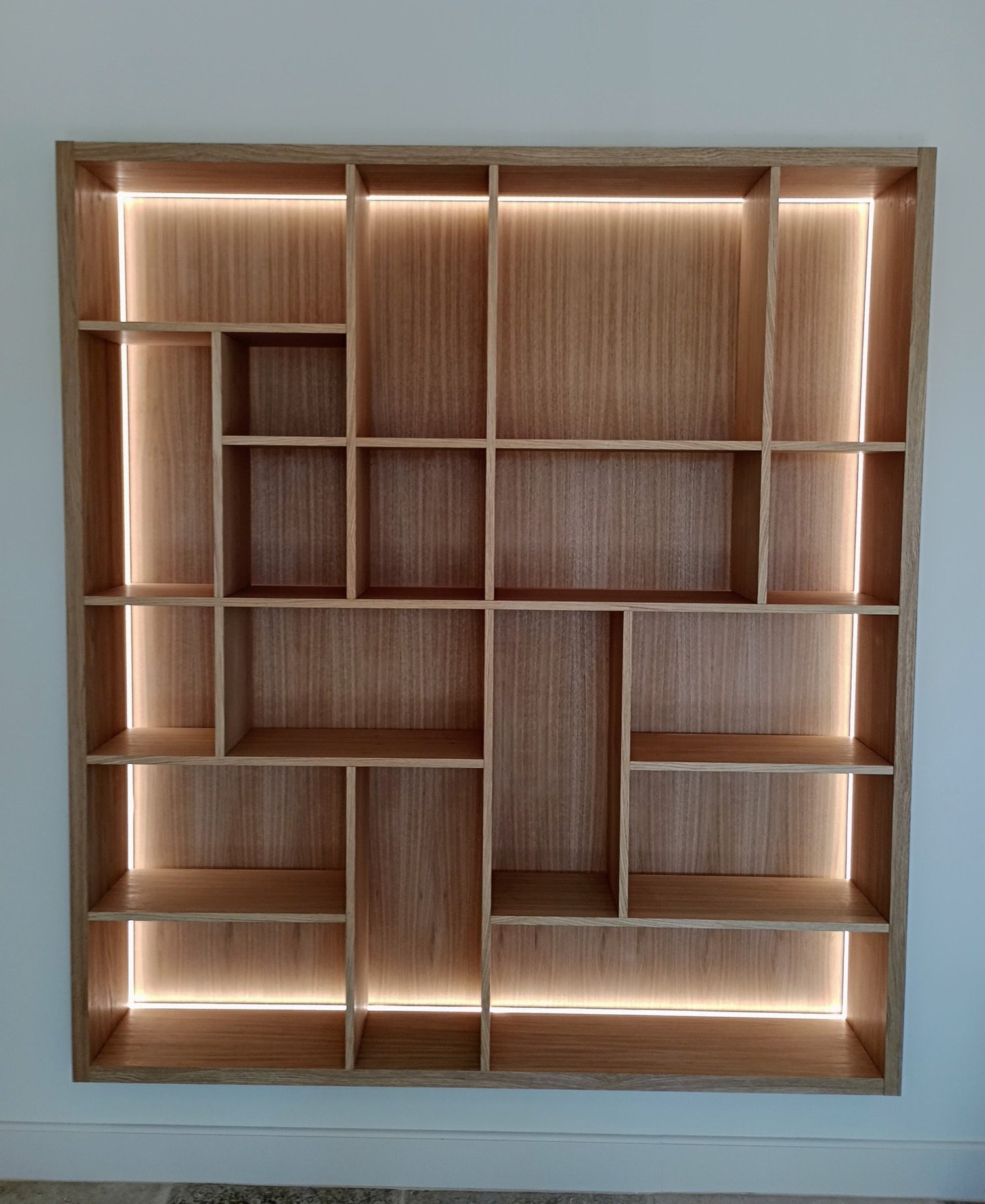 Étagère en bois avec plusieurs compartiments et éclairage LED intégré.